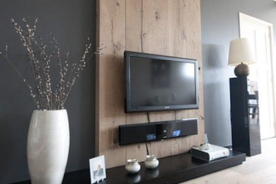 Exemple d'un grand salon tendance ouvert avec une salle de réception, un mur noir, parquet clair et un téléviseur fixé au mur.