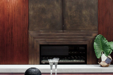 Mittelgroßes, Repräsentatives Modernes Wohnzimmer im Loft-Stil mit brauner Wandfarbe, dunklem Holzboden, Gaskamin, Kaminumrandung aus Metall und verstecktem TV in Los Angeles