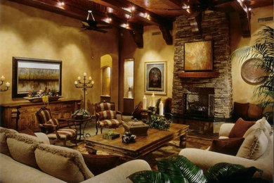 フェニックスにある高級な広い地中海スタイルのおしゃれなリビング (ベージュの壁、スレートの床、標準型暖炉、石材の暖炉まわり) の写真