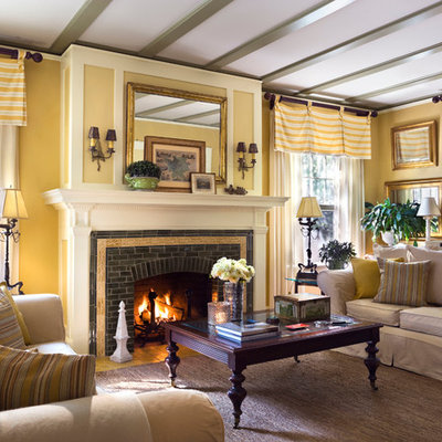 Elegant enclosed living room photo in New York with yellow walls, a standard fireplace and a brick fireplace