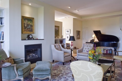 This is an example of a medium sized traditional formal living room in Cincinnati with white walls, light hardwood flooring, a standard fireplace, a metal fireplace surround and brown floors.