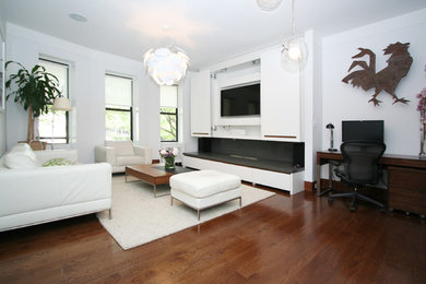 Example of a trendy dark wood floor living room design in New York with white walls, a standard fireplace, a stone fireplace and a media wall
