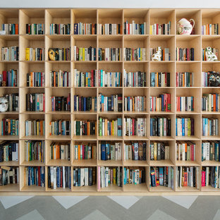 Foto på ett mellanstort funkis allrum med öppen planlösning, med ett bibliotek, vita väggar, linoleumgolv, en öppen vedspis och en spiselkrans i sten