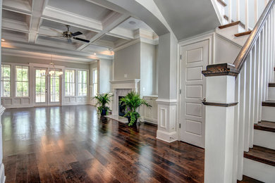 Klassisches Wohnzimmer mit grauer Wandfarbe, dunklem Holzboden, Kamin und Kaminumrandung aus Stein in Wilmington