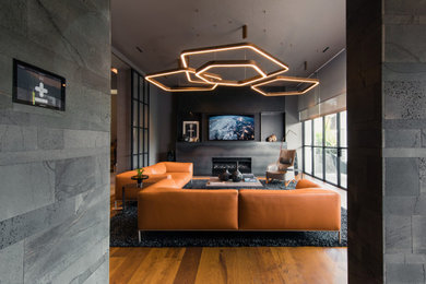 Réalisation d'un grand salon design ouvert avec un sol en bois brun, un manteau de cheminée en pierre et un sol marron.