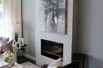 Inspiration for a mid-sized modern open concept dark wood floor, vaulted ceiling and gray floor living room remodel in Calgary with blue walls, a standard fireplace and a tile fireplace