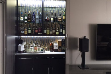 Medium sized contemporary home bar in Los Angeles with light hardwood flooring.