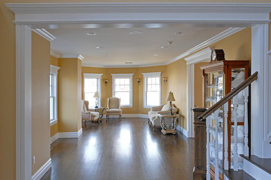 Ejemplo de salón para visitas abierto tradicional renovado de tamaño medio sin chimenea y televisor con paredes amarillas, suelo de madera oscura y suelo marrón
