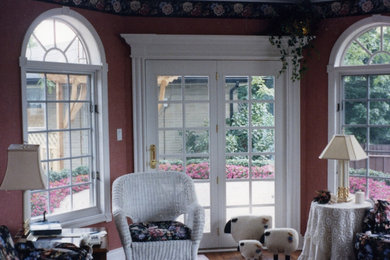 Foto di un soggiorno con pareti rosse e pavimento in legno massello medio
