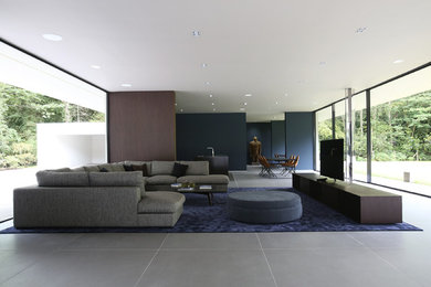 Photo of a large contemporary open plan living room in London with blue walls and a freestanding tv.