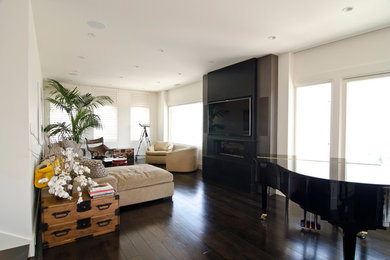 Imagen de salón con rincón musical abierto contemporáneo de tamaño medio con paredes blancas, suelo de madera oscura, chimenea lineal, televisor colgado en la pared y suelo marrón
