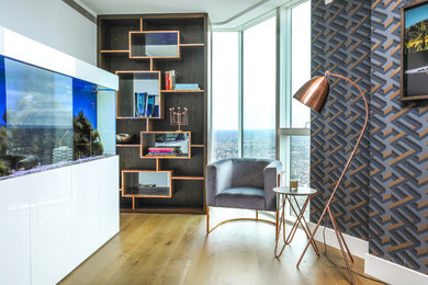 Esempio di un soggiorno minimal di medie dimensioni e chiuso con libreria, pavimento in legno massello medio, pareti bianche e pavimento marrone