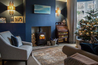 Imagen de salón cerrado tradicional pequeño con paredes azules, estufa de leña y suelo gris