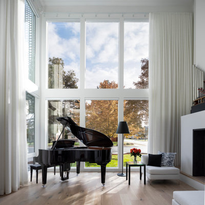 Living room - small contemporary open concept light wood floor and vaulted ceiling living room idea in Denver with white walls, a standard fireplace and a plaster fireplace