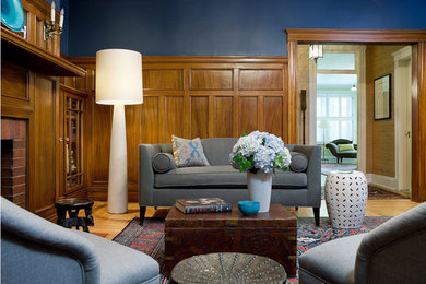 Inspiration for a mid-sized transitional enclosed light wood floor living room library remodel in Boston with blue walls, a standard fireplace, a brick fireplace and no tv