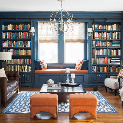 Example of a transitional medium tone wood floor living room library design in New York with blue walls and no tv