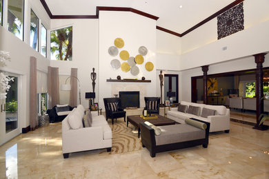 Cette image montre un grand salon design ouvert avec une salle de réception, un mur blanc, un sol en marbre, une cheminée standard, un manteau de cheminée en pierre, aucun téléviseur et un sol beige.