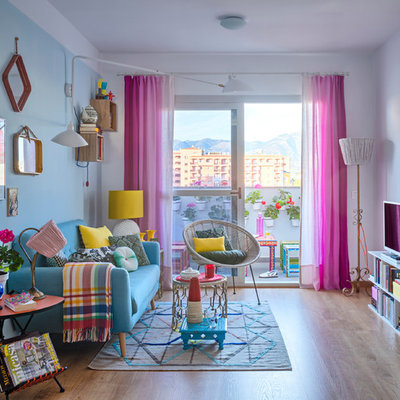 Inspiration for a mid-sized eclectic formal and enclosed light wood floor living room remodel in Malaga with blue walls and a tv stand