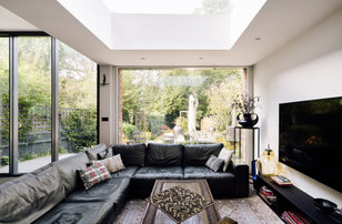 Bohemian open plan living room in London with white walls and a wall mounted tv.