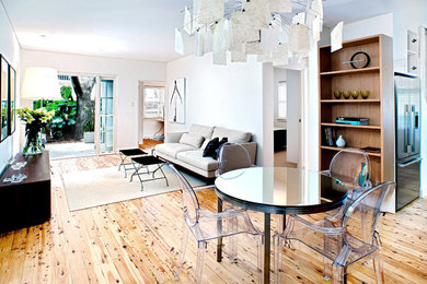 Imagen de salón abierto minimalista de tamaño medio sin chimenea y televisor con suelo de madera clara y paredes blancas