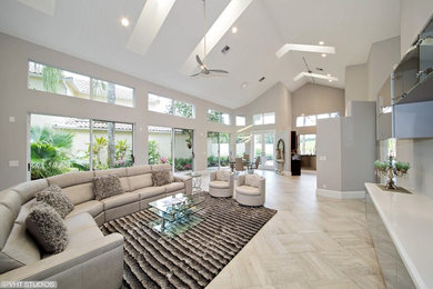 Offenes Modernes Wohnzimmer mit grauer Wandfarbe, Porzellan-Bodenfliesen und TV-Wand in Miami