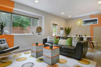Mittelgroßes, Offenes Wohnzimmer ohne Kamin mit grauer Wandfarbe, Betonboden und TV-Wand in Austin