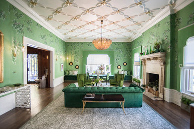 Idée de décoration pour un salon bohème fermé avec une salle de réception, un mur vert, parquet foncé, une cheminée standard et un manteau de cheminée en pierre.