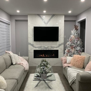 Modernes Wohnzimmer mit grauer Wandfarbe, braunem Holzboden, Kamin, gefliester Kaminumrandung und türkisem Boden in Toronto