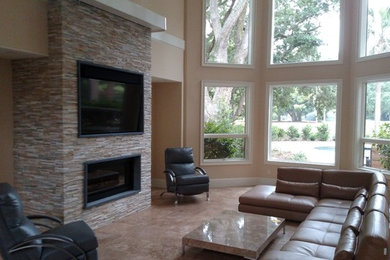 Living room - mid-sized contemporary formal and open concept concrete floor and beige floor living room idea in Atlanta with beige walls, a standard fireplace, a stone fireplace and a wall-mounted tv