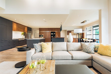 Foto de salón para visitas abierto moderno de tamaño medio con paredes blancas, suelo de madera clara y suelo marrón
