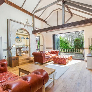 Photo of a mediterranean open plan living room in Kent with white walls, medium hardwood flooring and brown floors.