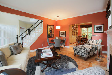 Example of a large transitional enclosed light wood floor living room design in Portland with orange walls, a standard fireplace and a stone fireplace