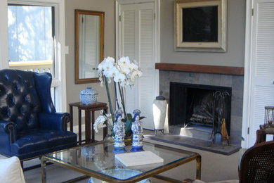 На фото: гостиная комната в стиле неоклассика (современная классика) с бежевыми стенами, фасадом камина из камня, стандартным камином и ковровым покрытием с