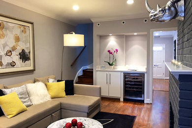 Example of a mid-sized trendy enclosed light wood floor living room design in DC Metro with gray walls, a standard fireplace, a brick fireplace and no tv