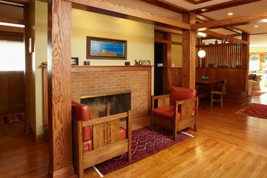 Imagen de salón de estilo americano con suelo de madera en tonos medios y marco de chimenea de ladrillo