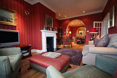Medium sized traditional open plan living room in Other with red walls, medium hardwood flooring and a standard fireplace.