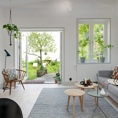 Example of a mid-sized danish open concept light wood floor living room design in Gothenburg with white walls, no fireplace and no tv
