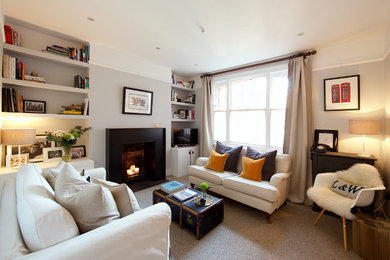 Photo of a victorian living room in London with grey walls, carpet, a metal fireplace surround and beige floors.