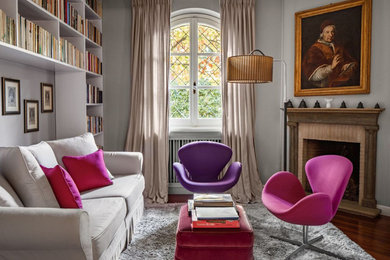 Inspiration for a traditional living room curtain in London with a reading nook, grey walls, medium hardwood flooring, a corner fireplace and brown floors.