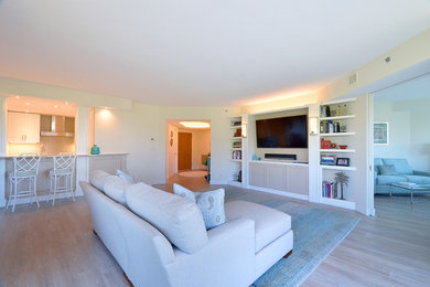 Foto de salón abierto clásico renovado grande sin chimenea con paredes beige, suelo de madera clara, televisor colgado en la pared y suelo beige