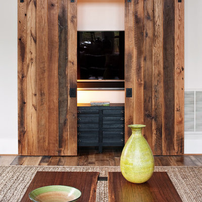 Example of a mountain style medium tone wood floor living room design in Richmond with white walls and a concealed tv