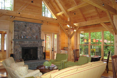 Inspiration for a mid-sized craftsman formal and open concept medium tone wood floor living room remodel in Portland Maine with a two-sided fireplace, a stone fireplace and a media wall