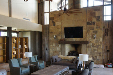 Example of a trendy limestone floor living room design in St Louis with black walls, a tile fireplace and a wall-mounted tv