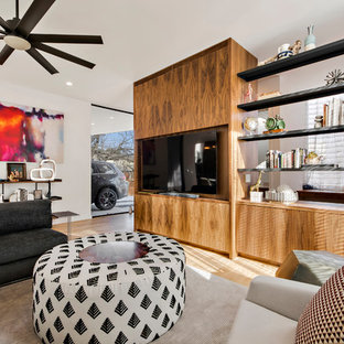 Example of a large trendy open concept light wood floor and beige floor living room design in Austin with white walls, no fireplace and a wall-mounted tv