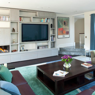 This is an example of a contemporary living room in London with beige walls, dark hardwood flooring, a ribbon fireplace and a built-in media unit.