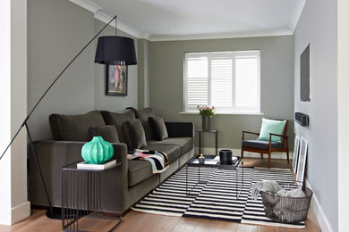 На фото: гостиная комната в стиле неоклассика (современная классика) с серыми стенами и светлым паркетным полом