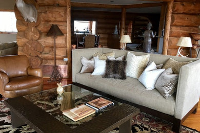 Foto de salón para visitas abierto rural de tamaño medio sin chimenea y televisor con paredes marrones, suelo de madera clara y suelo marrón