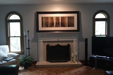Diseño de salón abierto clásico de tamaño medio sin televisor con paredes grises, suelo de madera en tonos medios, todas las chimeneas, marco de chimenea de baldosas y/o azulejos y suelo marrón