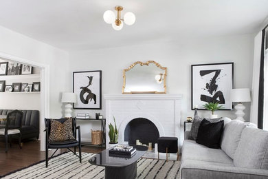 Kleines, Abgetrenntes Modernes Wohnzimmer mit weißer Wandfarbe, dunklem Holzboden, Kamin, Kaminumrandung aus Backstein, freistehendem TV und braunem Boden in Toronto
