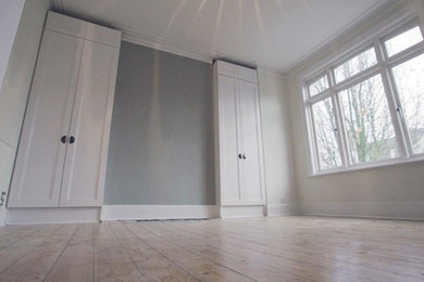Imagen de salón cerrado clásico de tamaño medio con paredes grises, suelo de madera pintada y suelo marrón